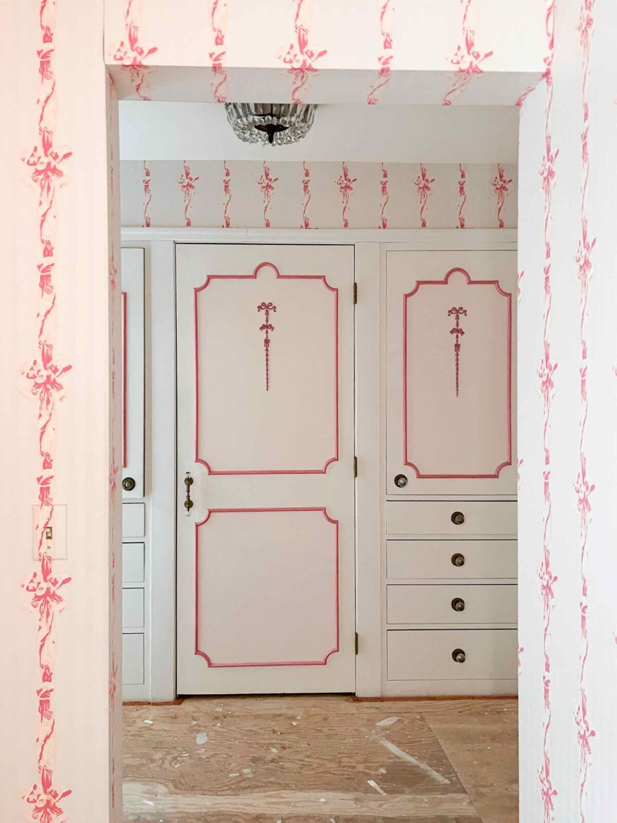 Dressing room with pink design details on the wallpaper and woodwork