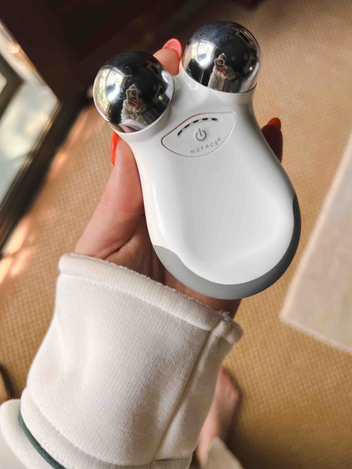 Hand holding a NuFACE Mini device