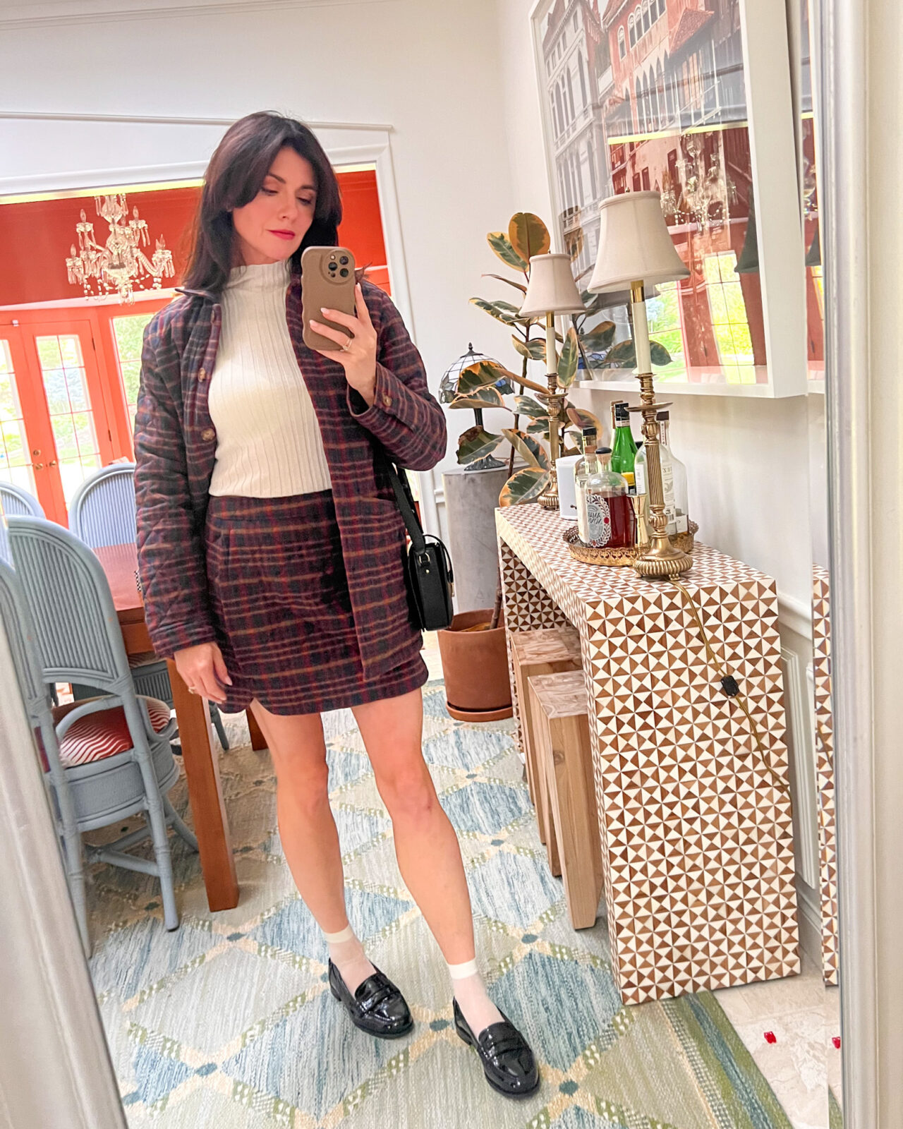 Mirror selfie of a matching tartan jacket and skirt. The outfit is finished off with black loafers. 