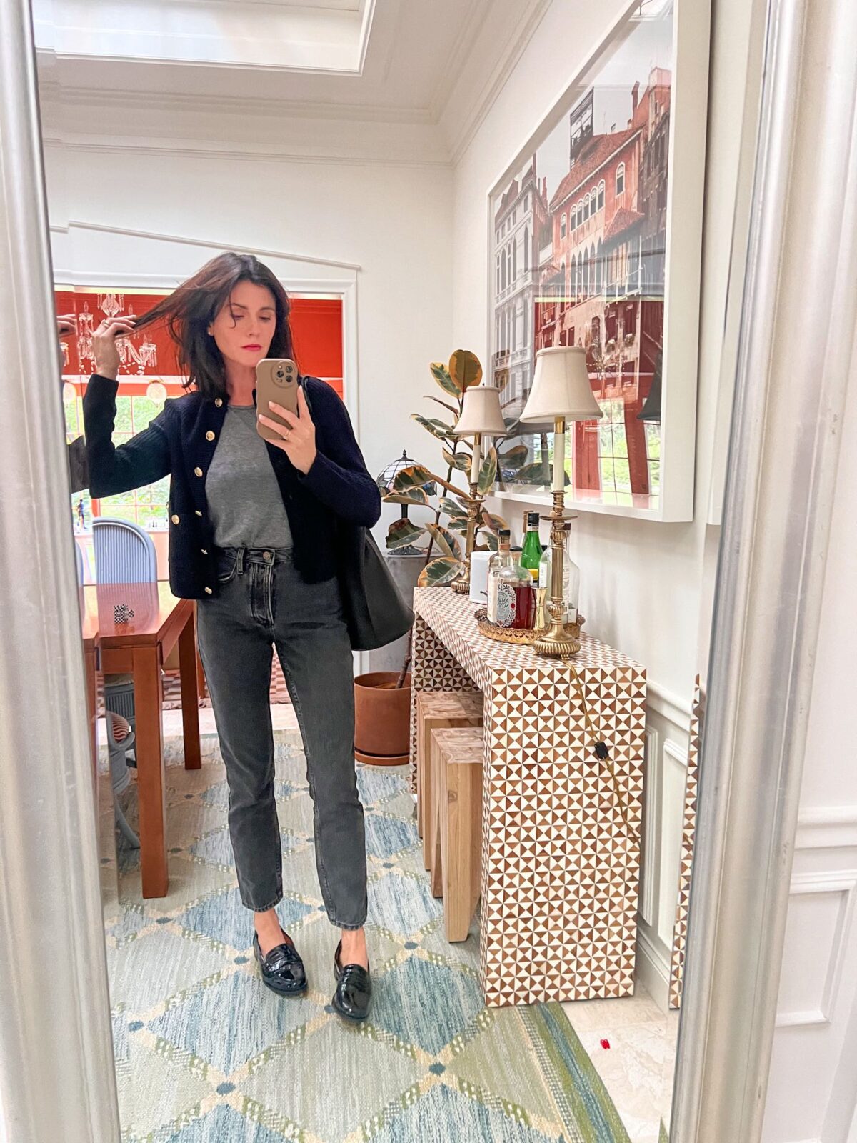 Mirror selfie of a woman wearing gray denim, a navy cardigan, and a gray shirt. 